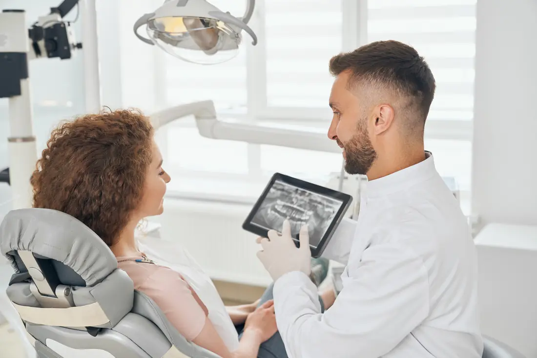 Medic stomatolog explicând radiografia dentară pe tabletă